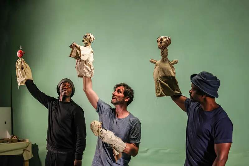 drei Männer halten Puppen in die Luft