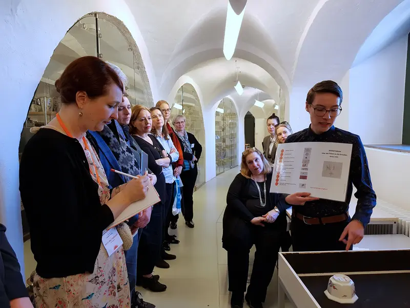 Kunstvermittlerin und Teilnehmende einer Führung in einem Ausstellungsraum