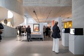 Ausstellungsansicht „Archiv der Träume. Ein surrealistischer Impuls“, 2024 Menschen in einem Ausstellungsraum mit kleinen Fernsehgeräten.