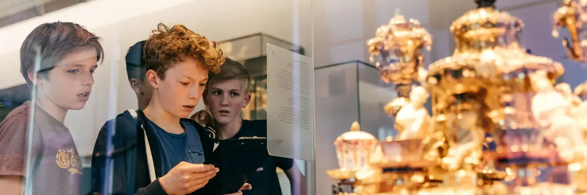 Drei Jungen stehen vor einem Museumsexponat  