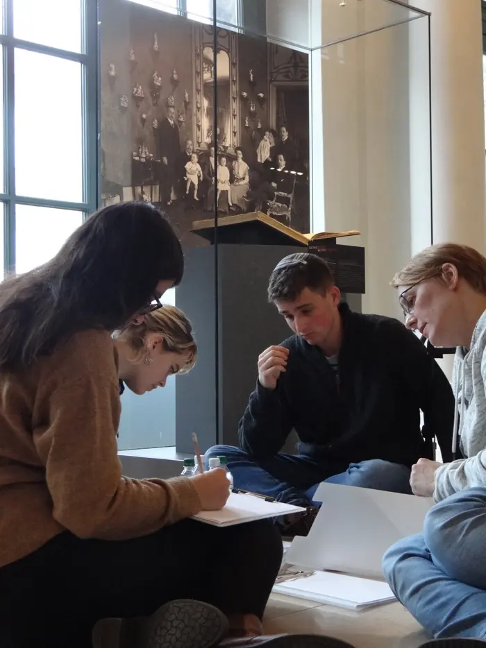 Vier Personen besprechen Zeichnungen, die vor ihnen liegen