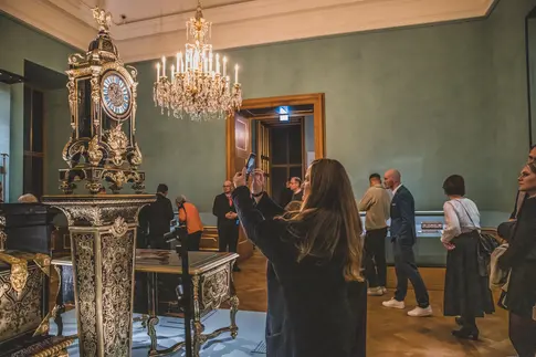 Frau in einem Raum, die ein Kunstwerk fotografiert