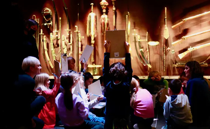 Bei einem Workshop in der Türckischen Kammer halten Kinder Klemmbretter hoch