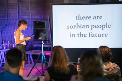 Eine Frau macht einen Vortrag auf der Bühne