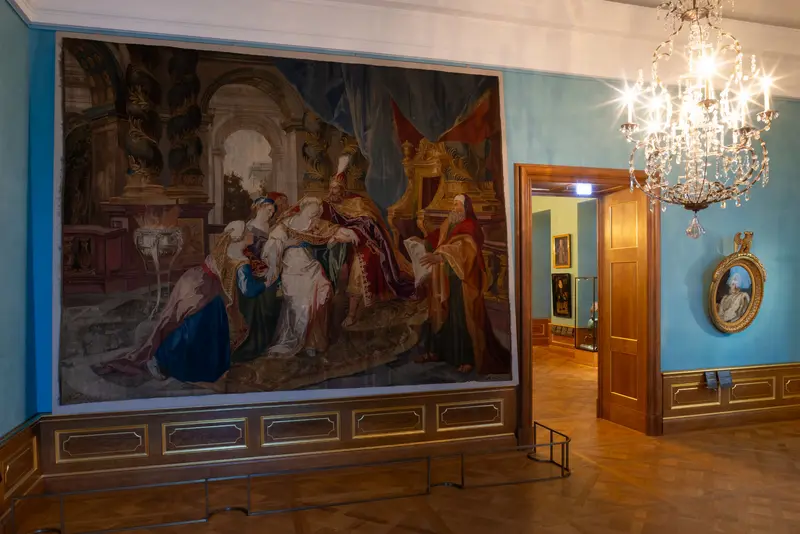 Raum mit großem Wandteppich und Kronleuchter