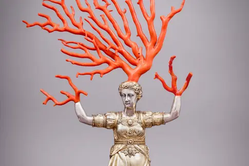 Frau mit geweihförmigen Korallen auf Kopf und anstelle von Händen