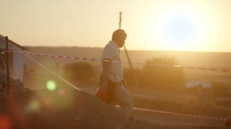 Mann vor einem Sonnenuntergang auf einer Ausgrabungsstätte