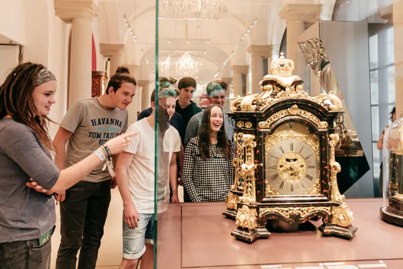 Eine Gruppe von Jugendlichen steht vor einem Museumsexponat