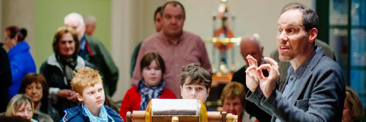 Ein Kurator des Mathematisch-Physikalischen Salons macht eine Führung für eine Kindergruppe