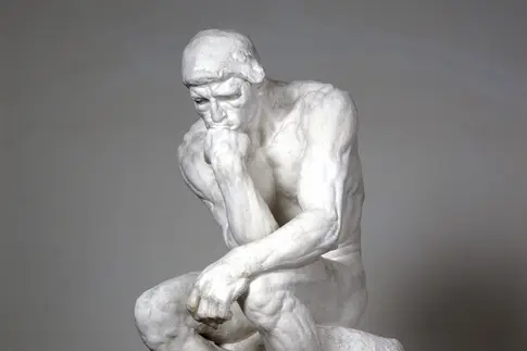 Skulptur eines nackten Mannes, der seinen Kopf auf die rechte Hand stützt