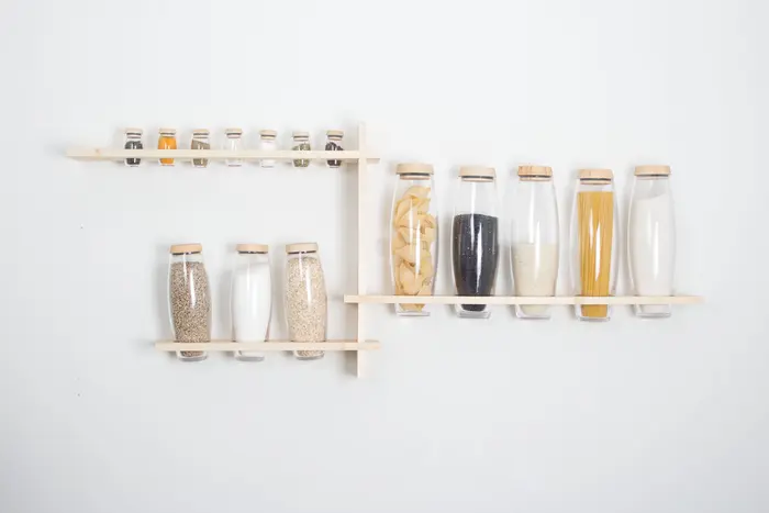 An der Wand hängen Glasflaschen mit Getreiden